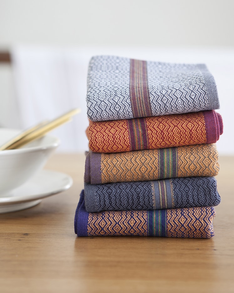 Mungo Table Linen Boma Napkins in White Stone, Orange Rust, Orange Sand, Black Indigo and Orange Indigo.