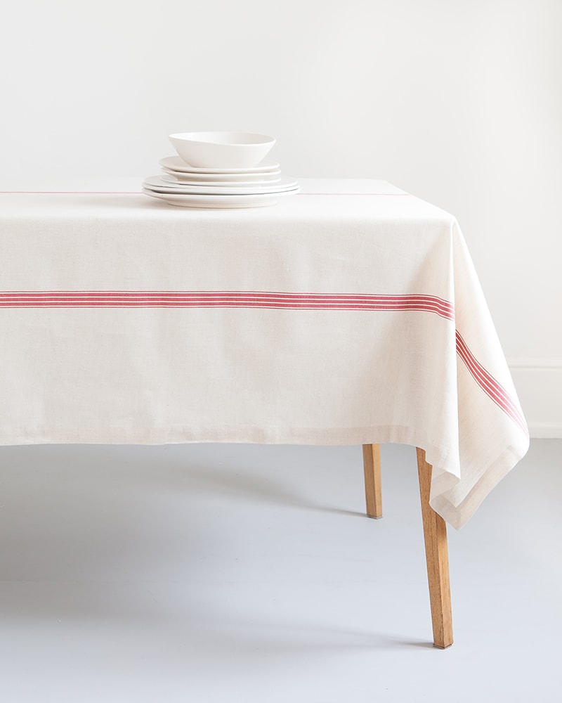The Mungo Linen Provincial Stripe Table Cloth in Natural and Red paired with white crockery for a crisp table setting.
