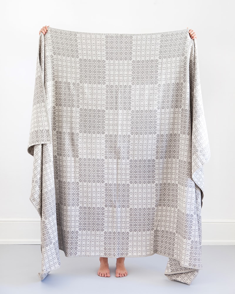 A Mungo Juno Cotton Blanket Throw in Grey, a textile woven with all natural fibres at our mill in Plettenberg Bay, South Africa.