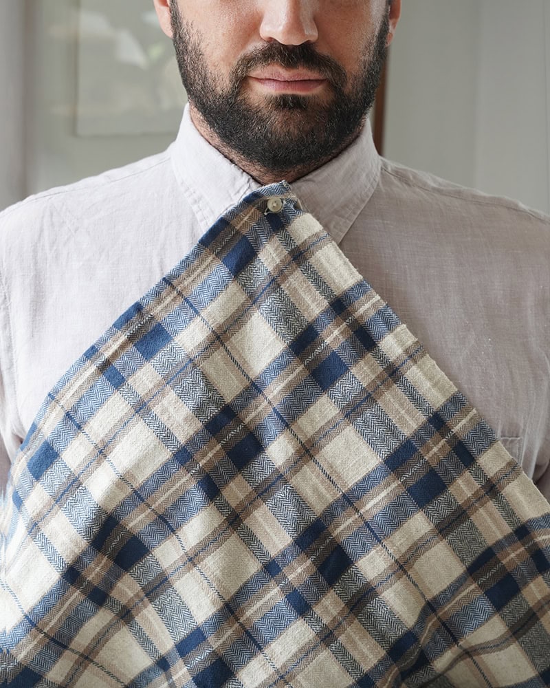 Man wearing the Oxford Cooks cloth, a cotton and linen kitchen cloth which features a button hole to hook on your top button for a fancy meal