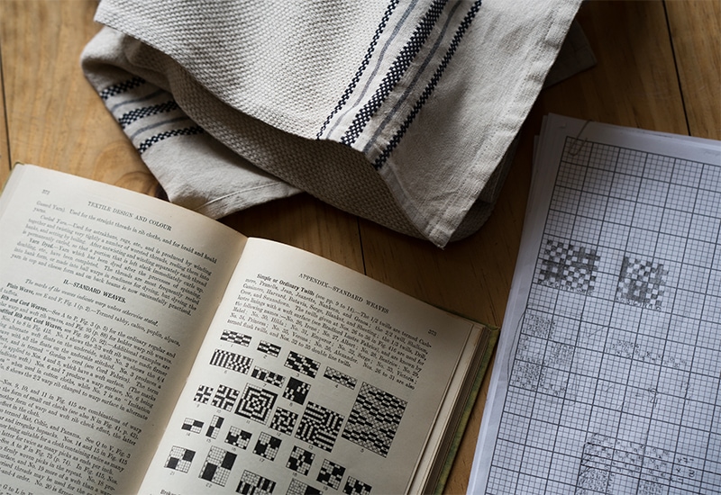 Antique hand loom pattern book being translated into a pattern card at the Mungo Mill in Plettenberg Bay