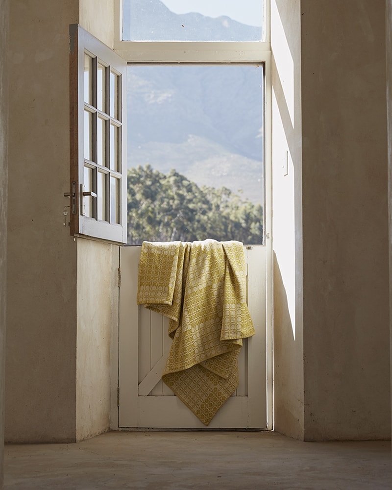Mungo Juno Throw in Mustard. 100% cotton throw, inspired by traditional 18th century American coverlets. Woven at the Mungo Mill in South Africa