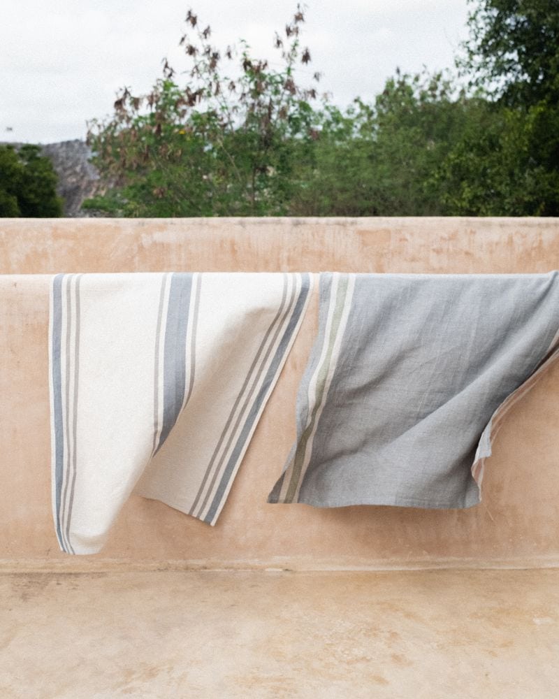 A huck towel and flax towel hanging on a wall
