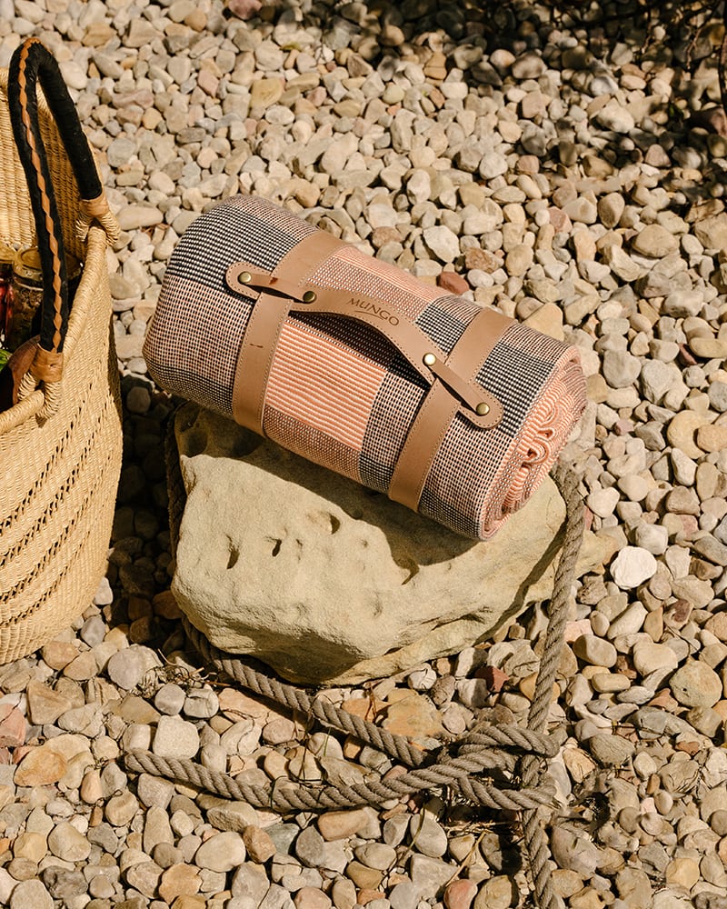 Mungo Picnic Blanket in Apricot. Photographed on a pebble beach in Knysna.