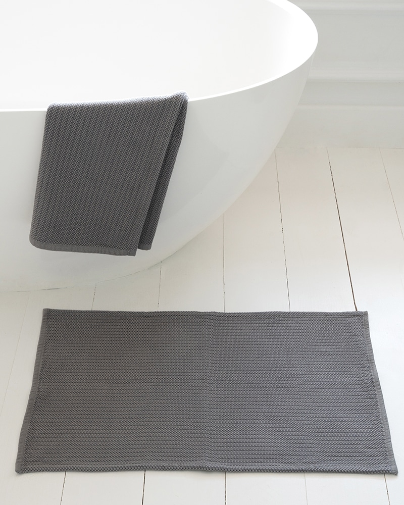 A stack of Mungo Cotton Rib Bath Mats. 100% soft, absorbent cotton.