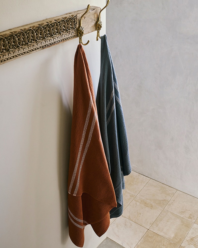 A bathroom with two towels hanging - the Mungo Organic Block Rib Towels. Organic cotton bath towels