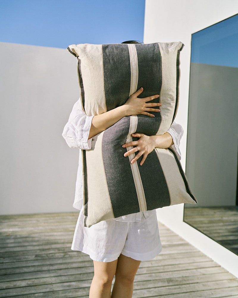 Model holding the large Mungo Cushion Cover in Navy
