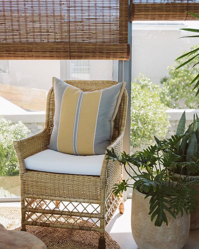 Barefoot Luxury is the Mungo Lisburn Linen Cushion on a Rattan chair