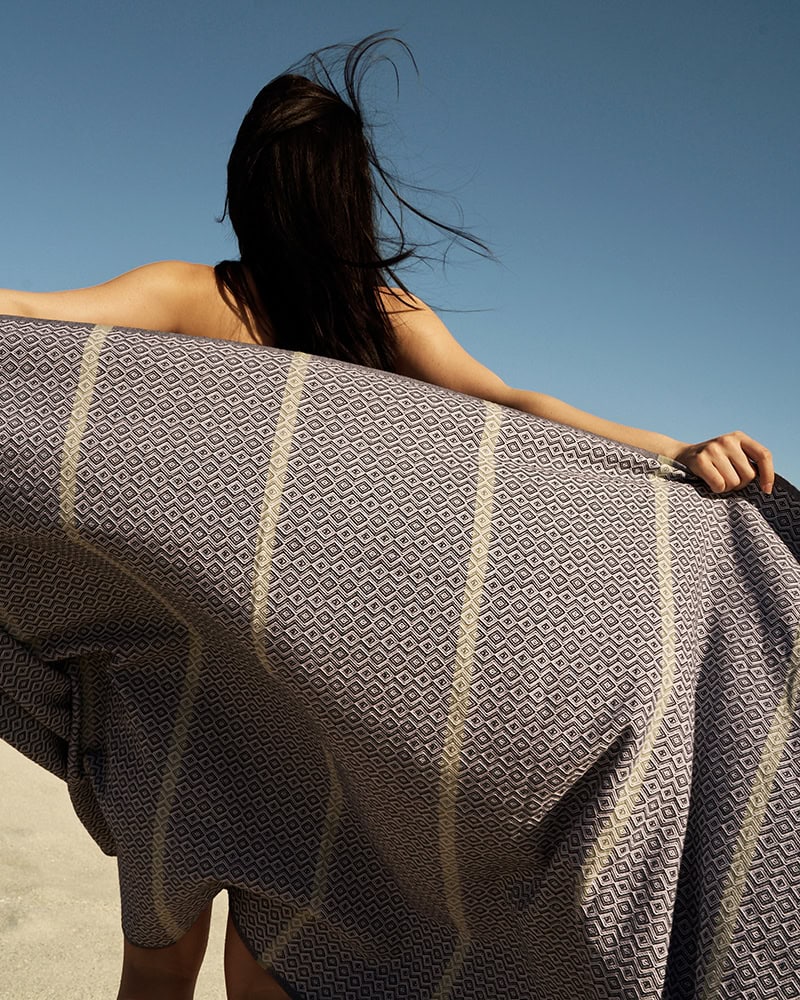 Girl at the beach with her Mungo beach towel. Made with 100% cotton by Mungo.