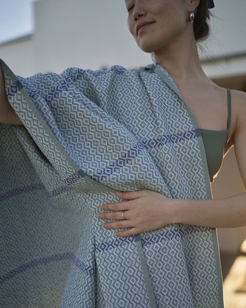 A model with her Mungo cotton beach towel. Natural fibre textiles woven in South Africa.