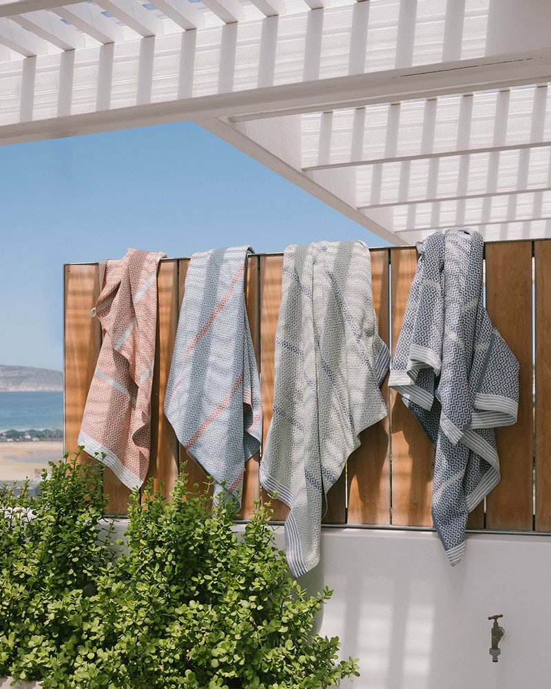Four cotton beach towels over a wall at the Walker's Beach Lodge in Plettenberg Bay, South Africa.