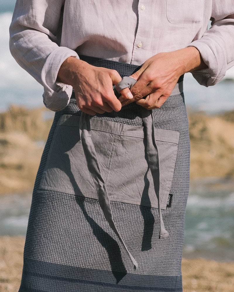 The Grill Apron in Oyster features long straps and a front pocket.