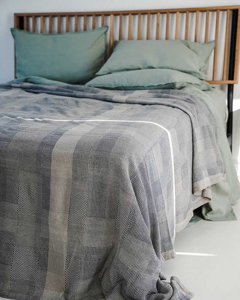 The linen and cotton Monsoon Savannah Blanket laying on a bed