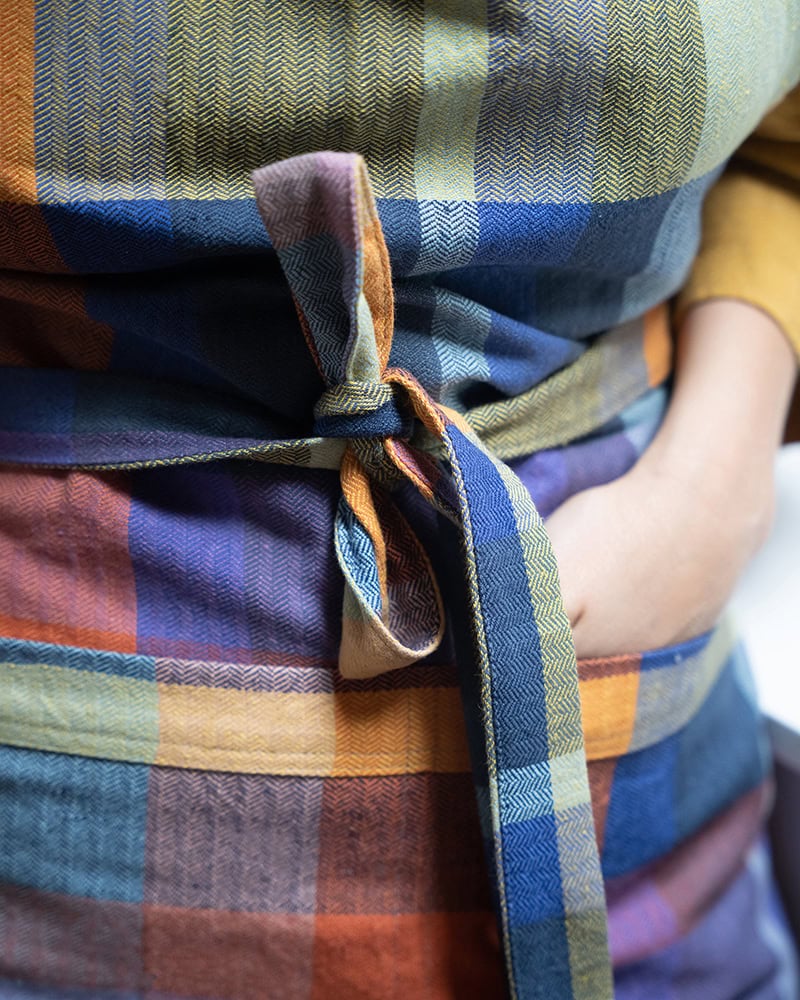 Close up view of the Mungo Alles Apron in Iris, showcasing its herringbone weave with double pockets.