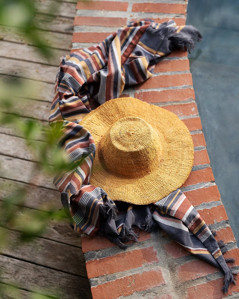 South Kikoi in Pewter next to a pool with a straw hat on top.