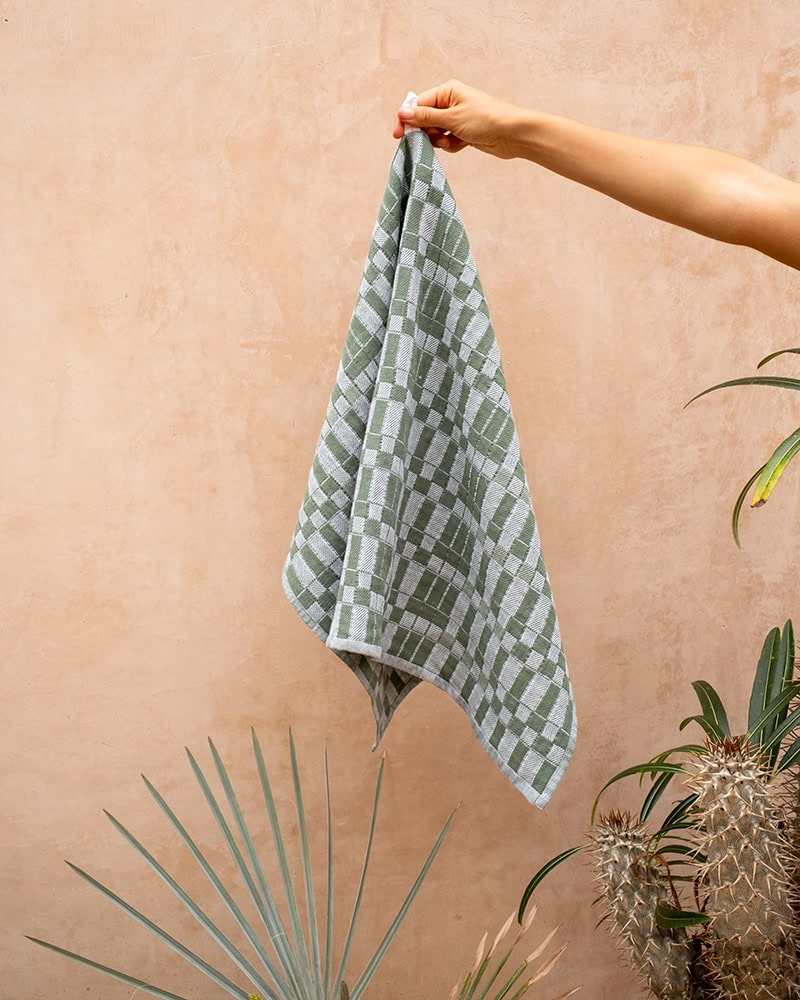 Hand holding the Mungo Pocket Weave Tea Towel in Chive