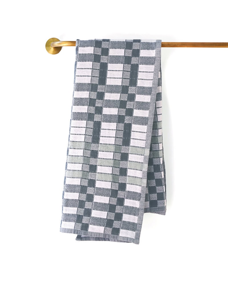 The Mungo Pocket Weave Tea Towel hanging over a rail, displaying it's unique block design and woven with 100% Organic cotton.